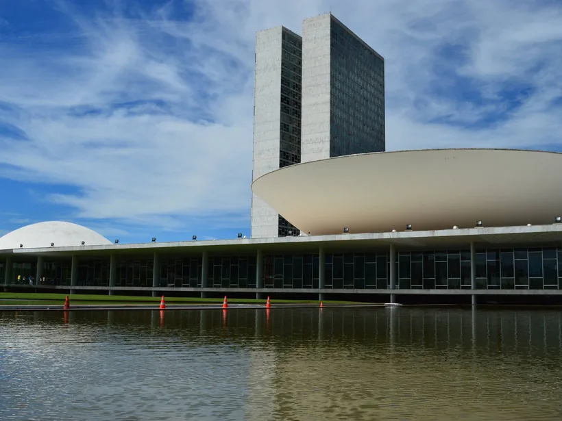 Cúpulas e torres gêmeas do Congresso Nacional refletidas no espelho de água, em Brasília